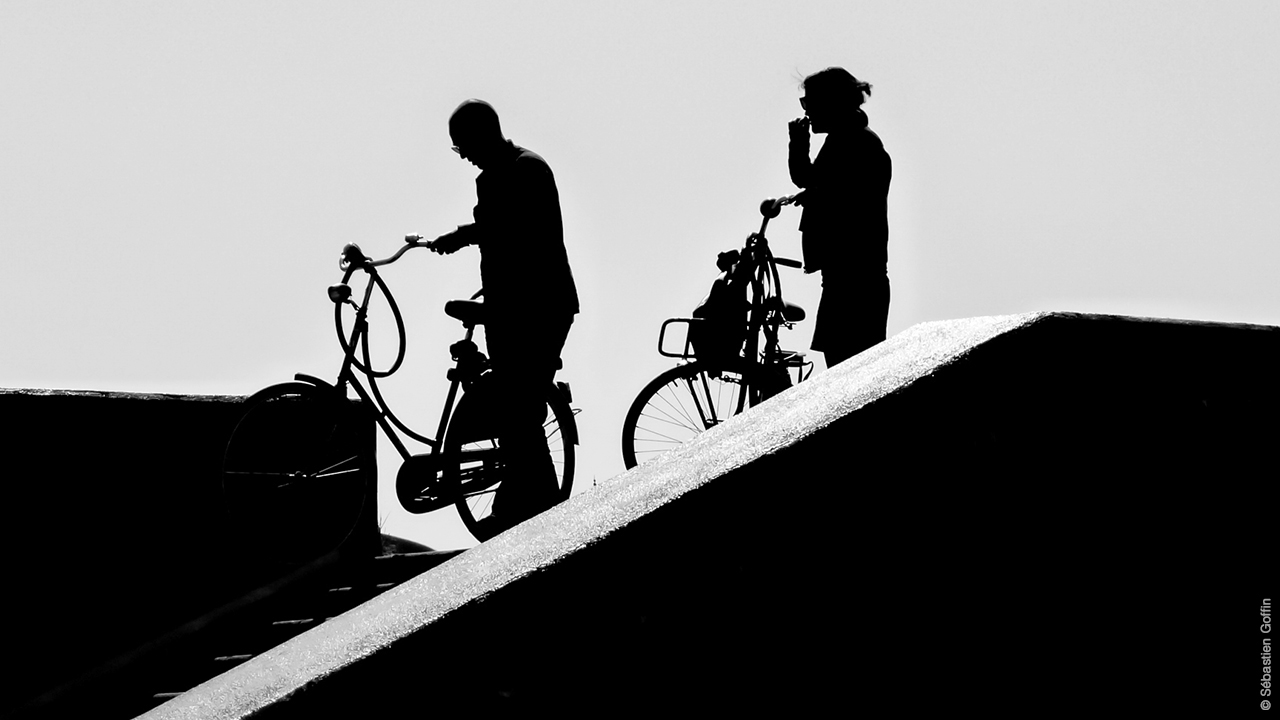 Photo noir et blanc de deux personnes en vélo, Amsterdam.